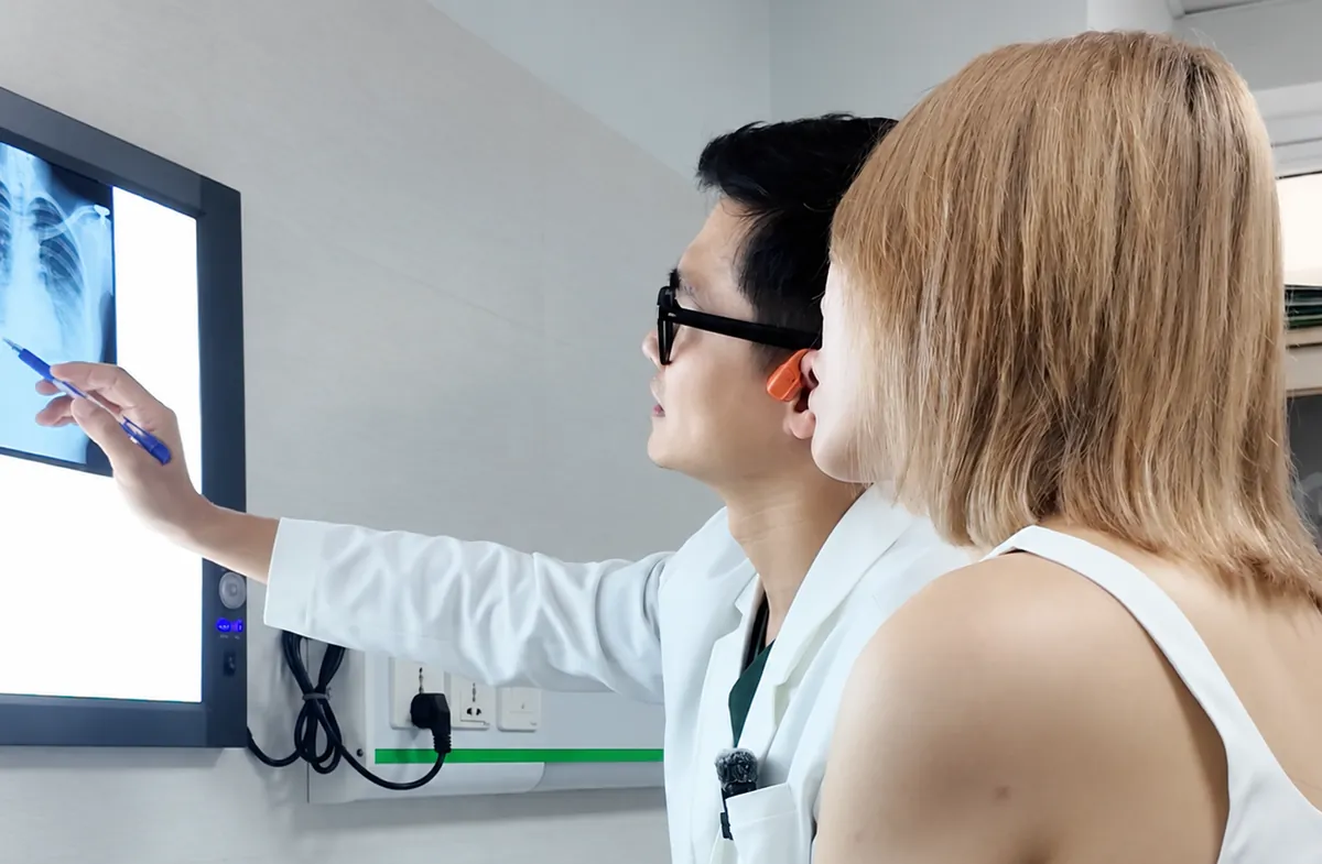 Bác sĩ đọc phim chụp cùng khách hàng trong buổi thăm khám