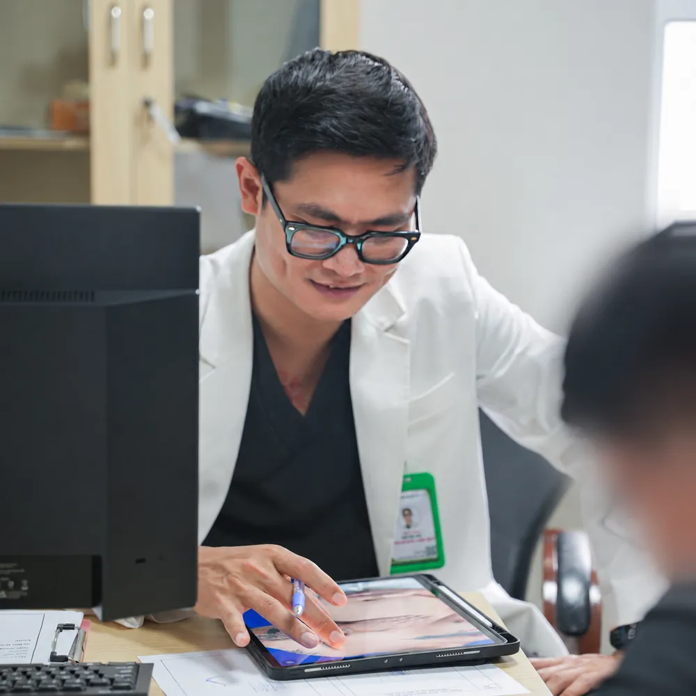 Bác sĩ xem lại hình ảnh cùng khách hàng trong buổi tái khám