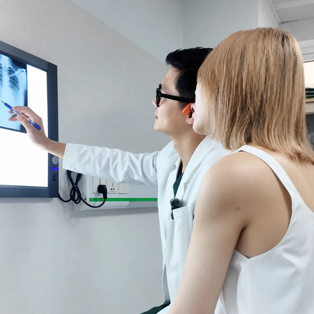 Bác sĩ đọc phim chụp và giải thích cho khách hàng trong buổi thăm khám